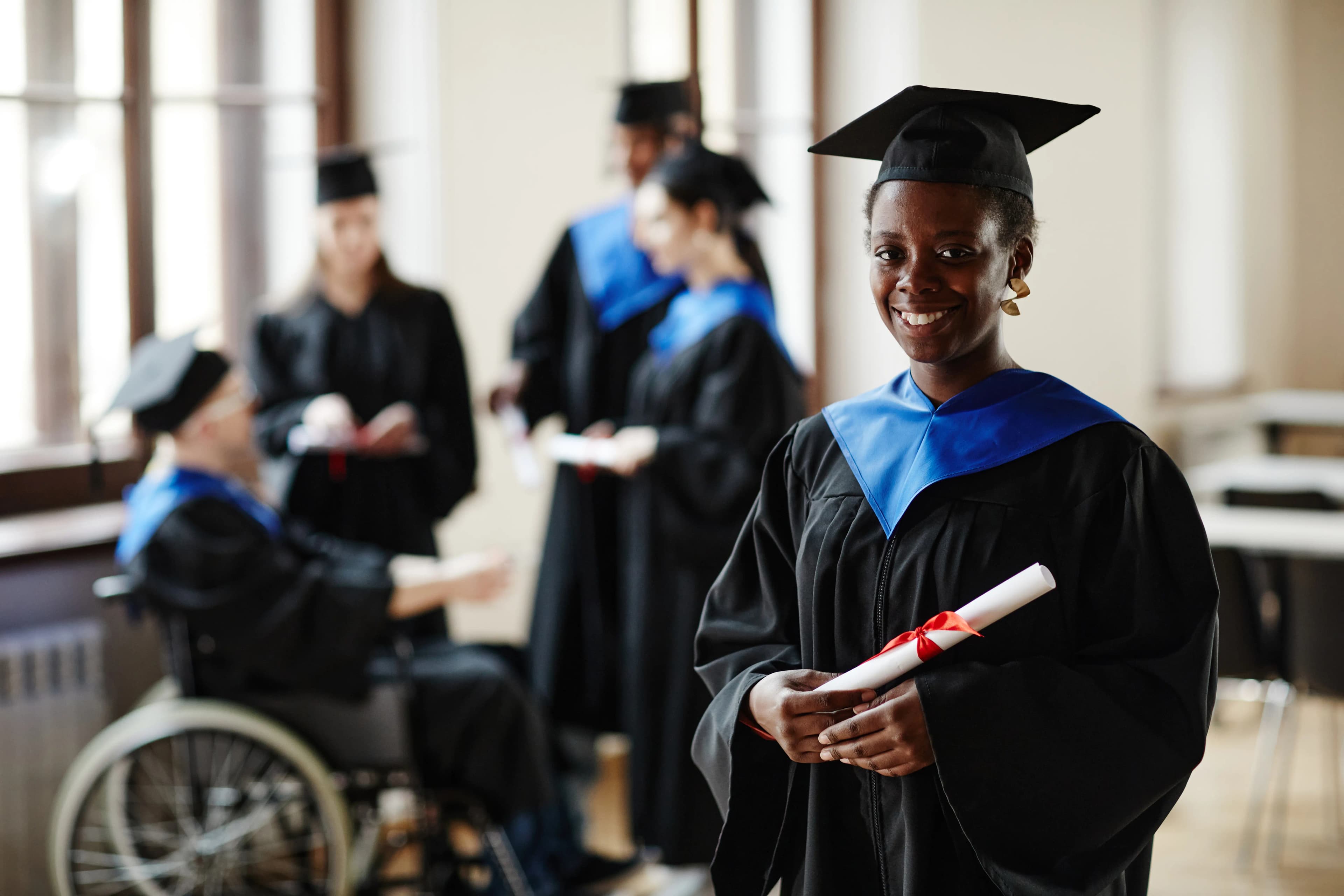 A Lumminx graduate holding her diploma after winning funded study abroad